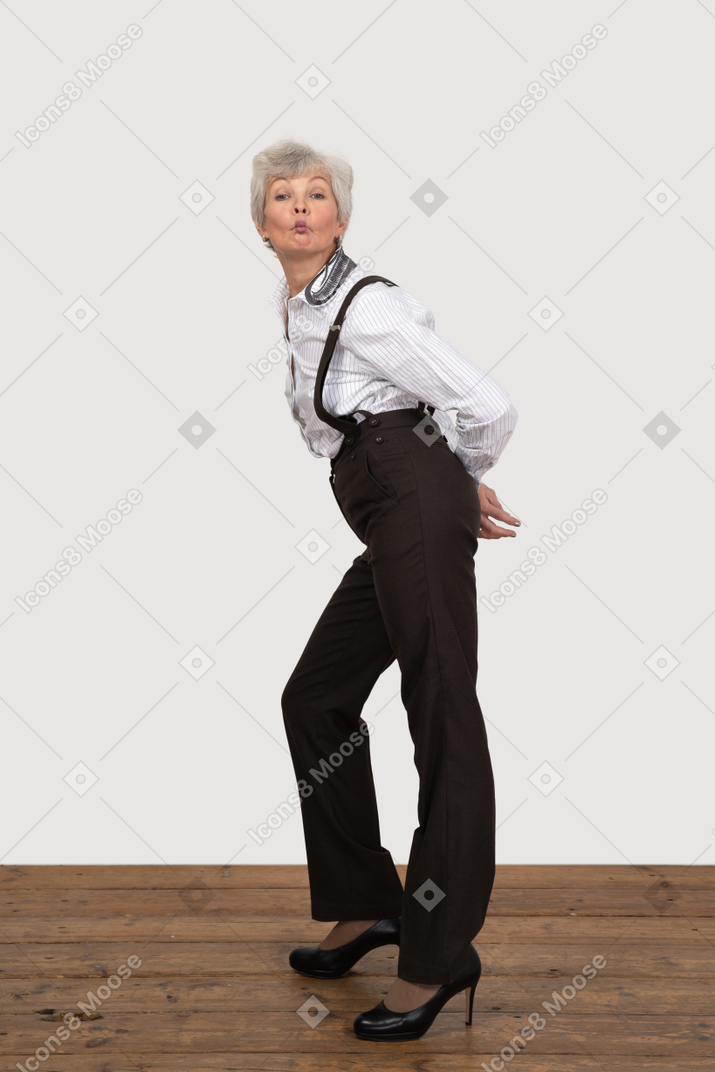 Vista lateral de una anciana sorprendida haciendo pucheros inclinándose hacia adelante