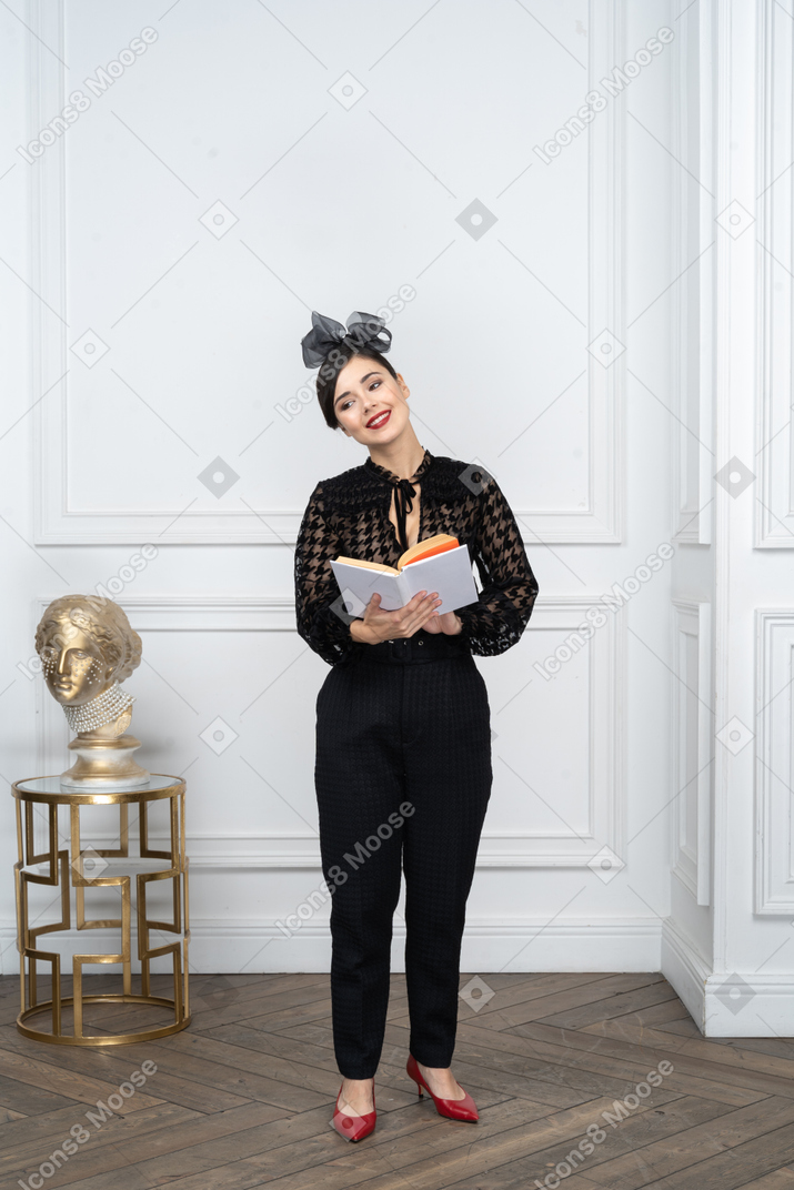 Jeune femme avec un livre dans les mains regardant de côté