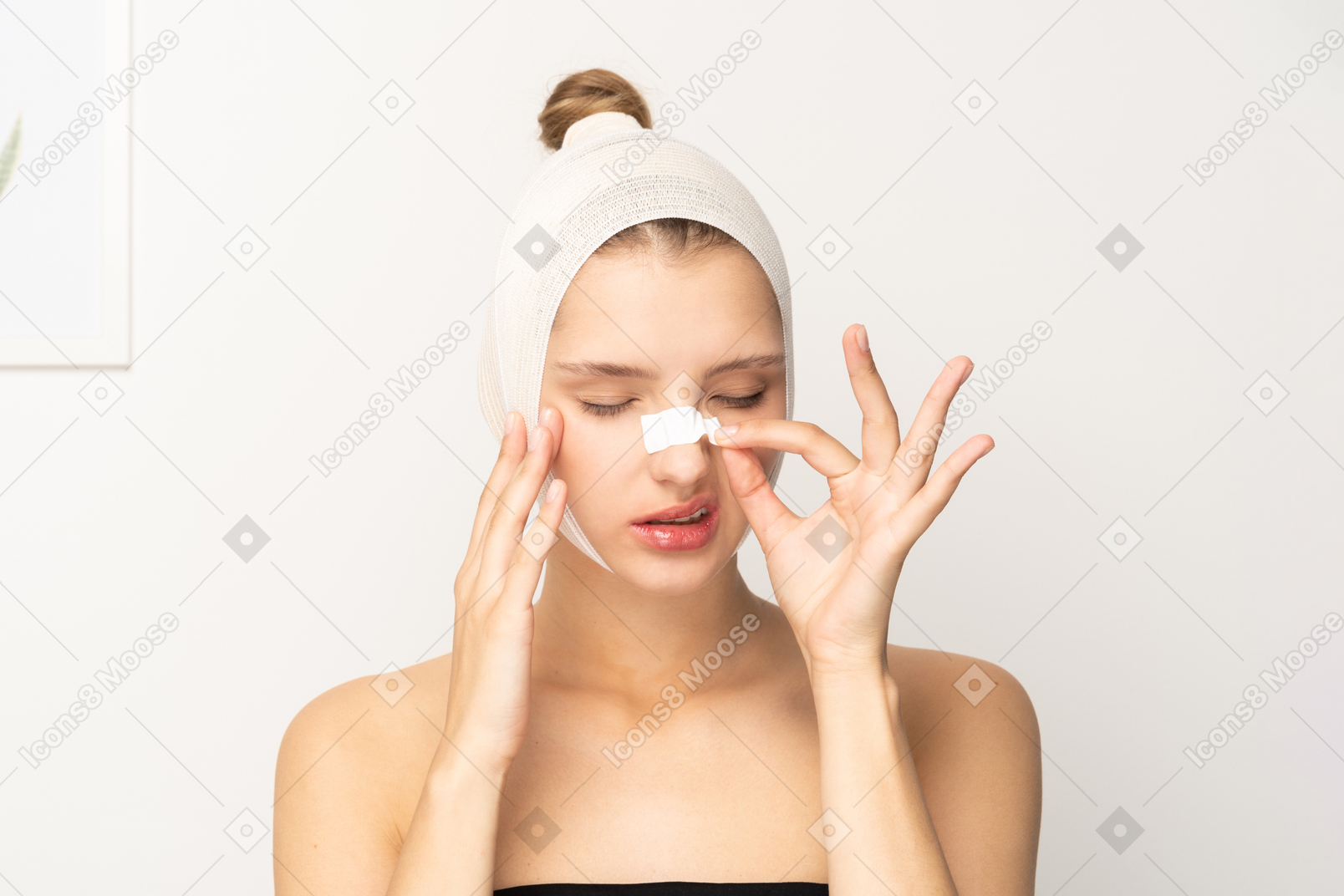 Female patient taking band aid off her nose