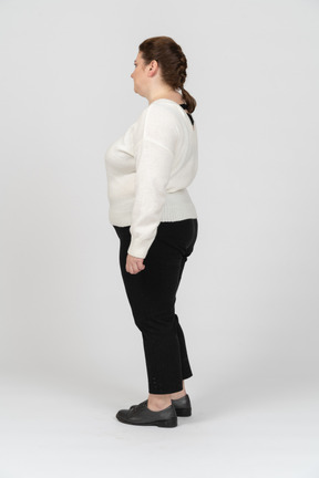 Plump woman in casual clothes standing in profile