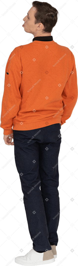 Junger mann im orangefarbenen sweatshirt stehend