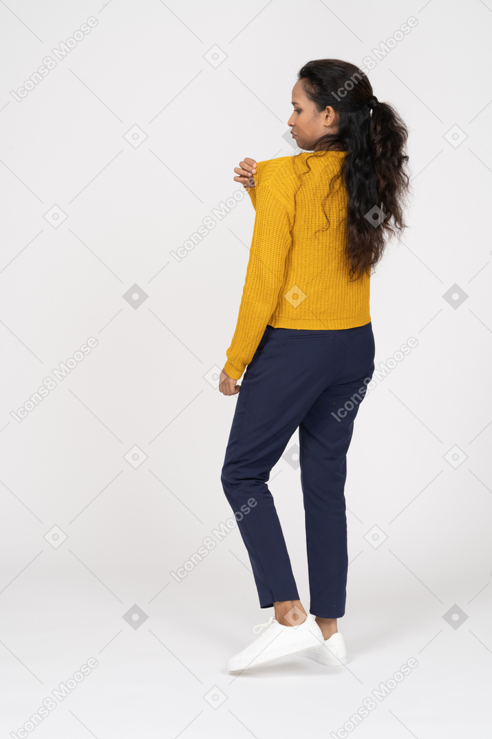Rear view of a girl in casual clothes touching shoulder