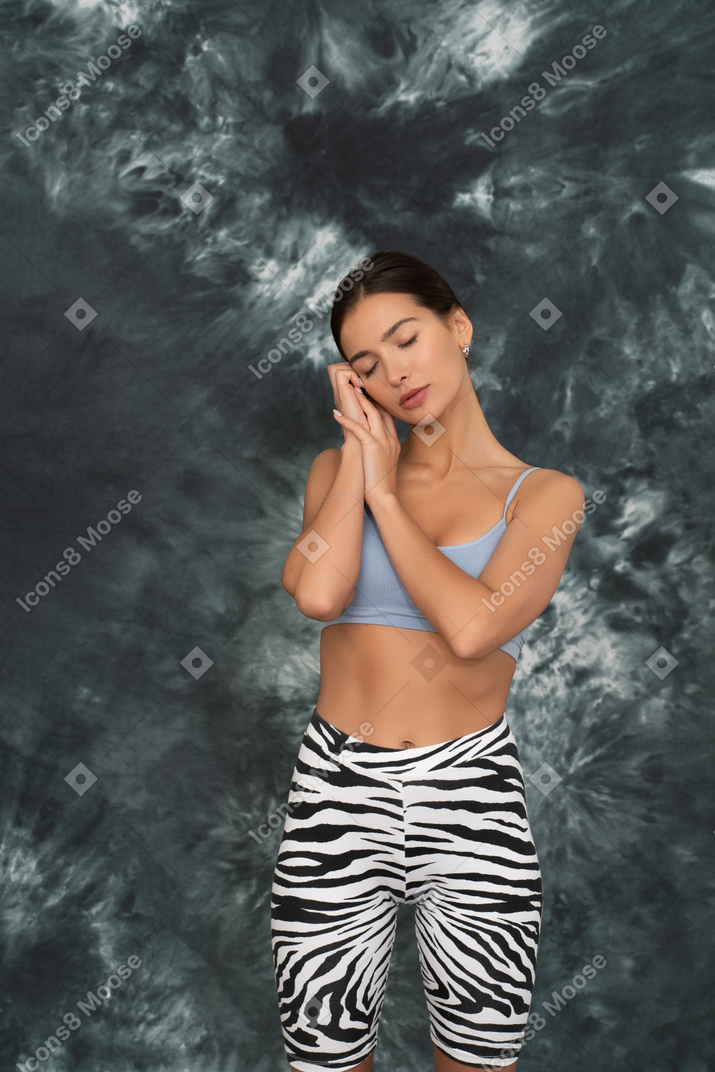 Young woman in a sports suit wants to sleep