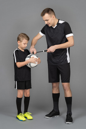 Full-length of a young man coaching little boy