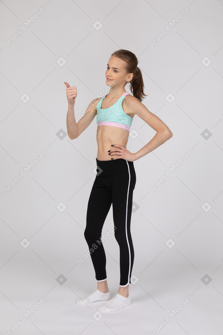 Una adolescente en ropa deportiva mostrando el pulgar hacia arriba