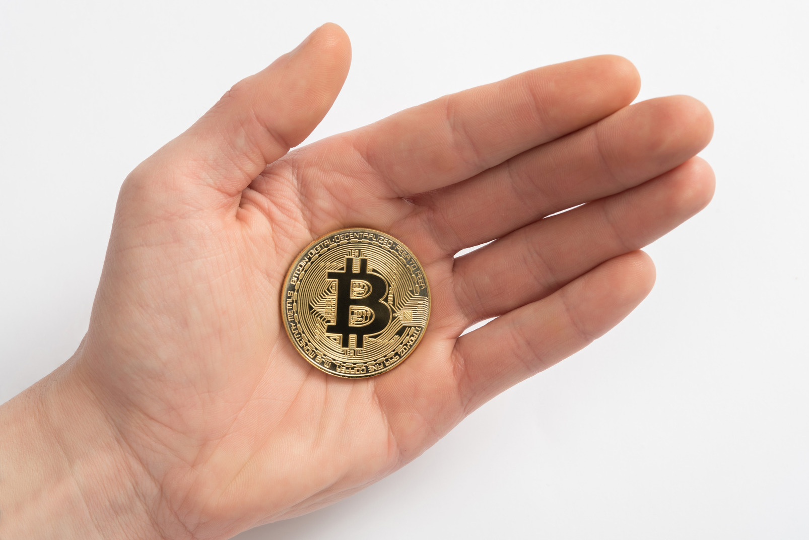 Male hand holding golden bitcoin