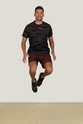 Молодой человек в спортивной одежде прыгает