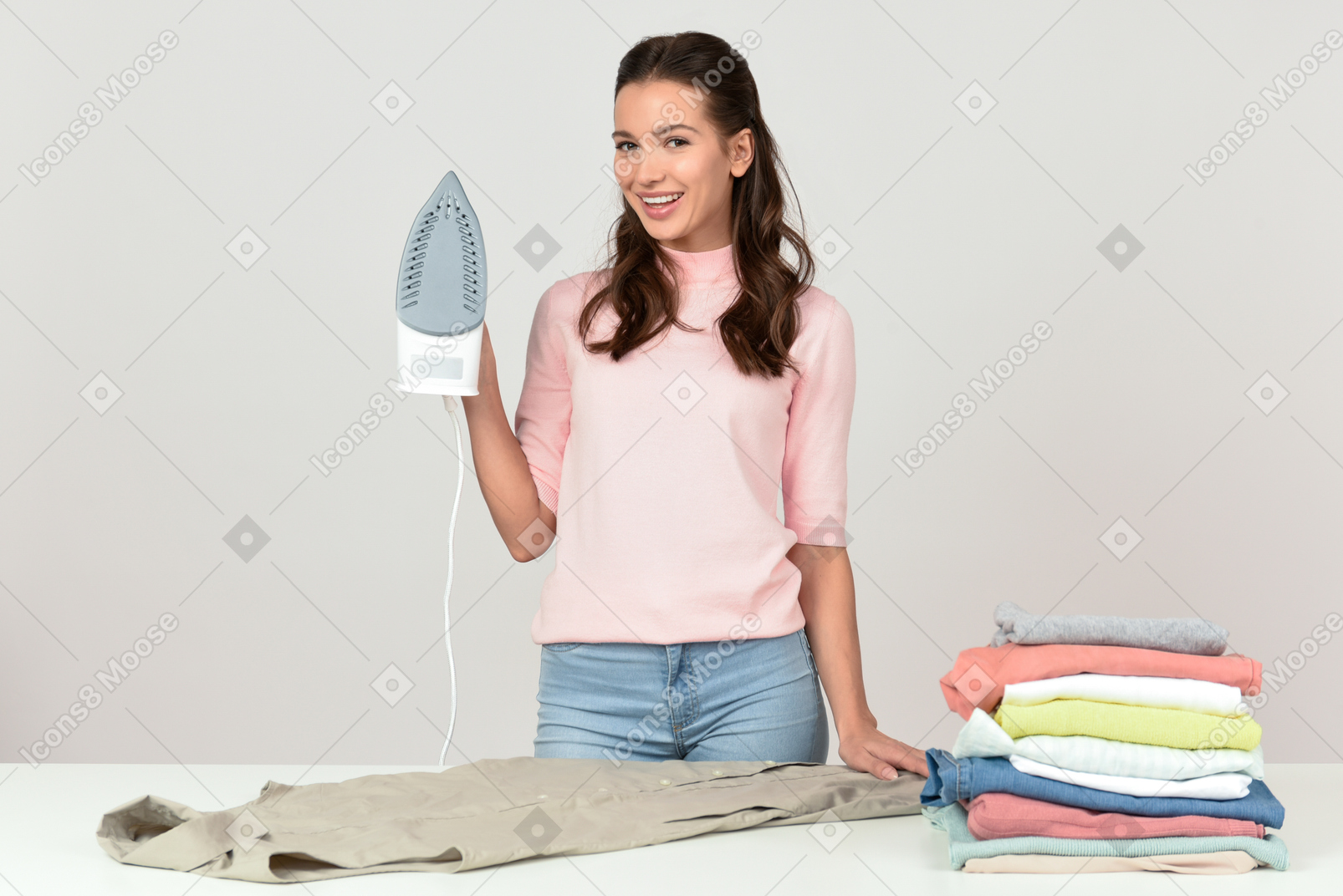 Attractive young woman with an iron looking pleased with herself