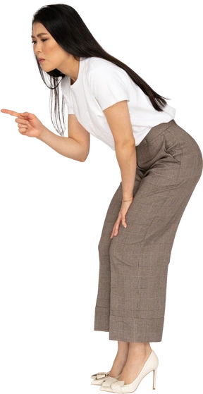 Three-quarter view of a strict young lady in breeches and t-shirt bending down