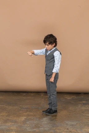 Side view of a boy in grey suit showing thumb down