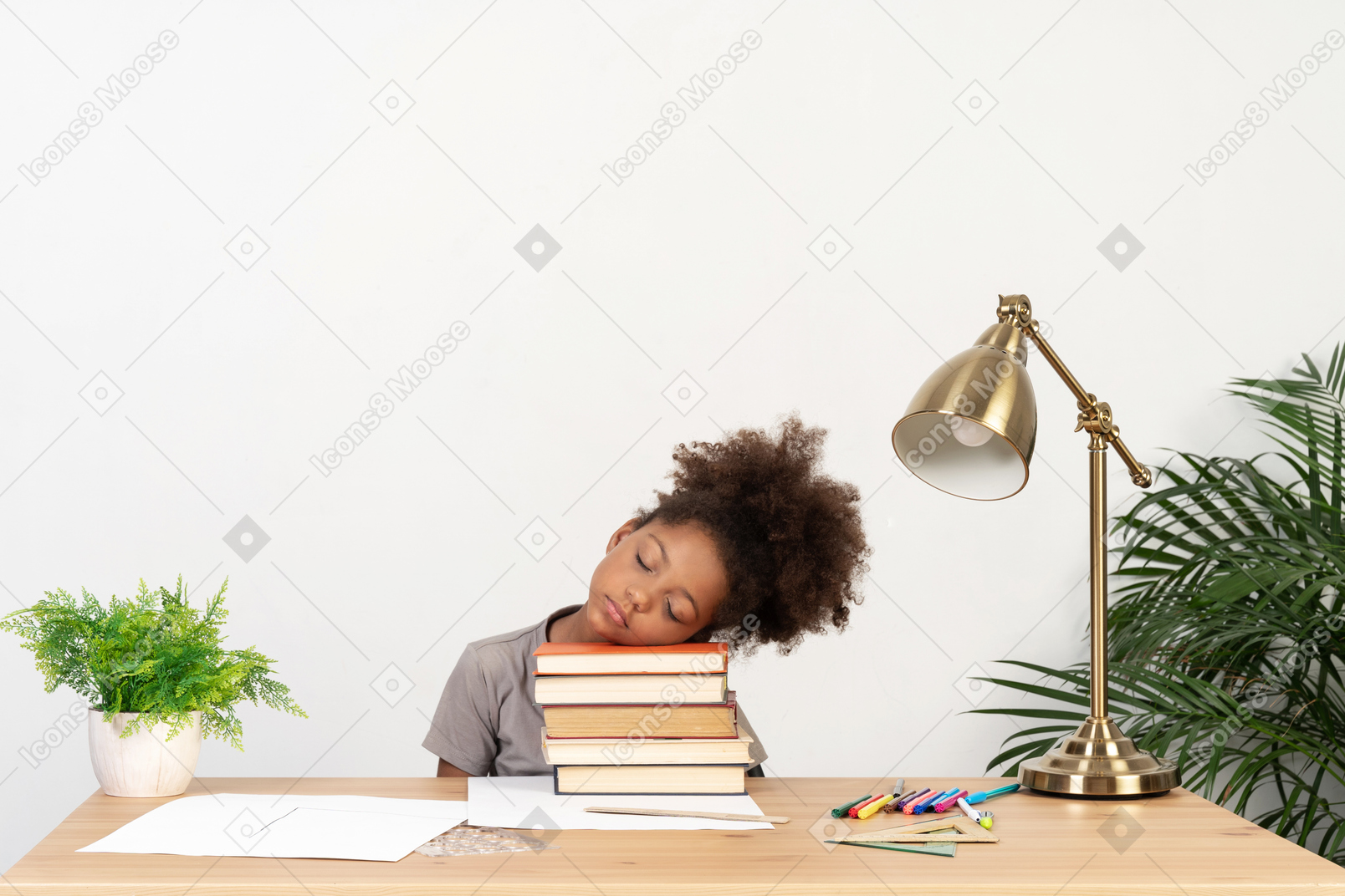Niña cansada con libros en la mesa