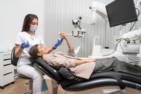 Full-length of a female dentist and her female patient looking at teeth model