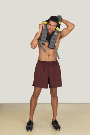Athletic man putting on weighted vest