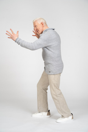 Side view of a middle-aged man reaching out his arms