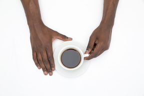 Schwarze männliche hände, die tasse schwarzen kaffee halten