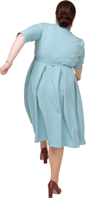青いドレスを歩いている女性の背面図