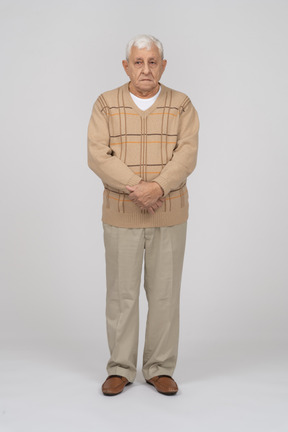 Front view of an old man in casual clothes looking at camera