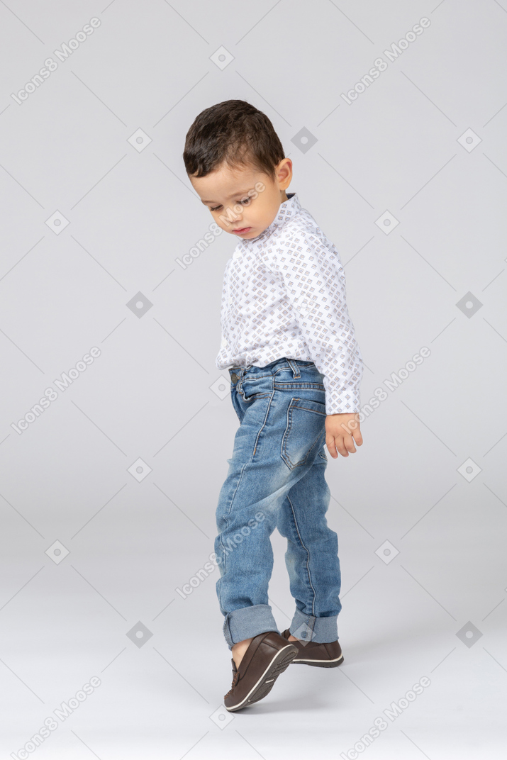 Little kid checking what's under his boot
