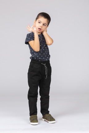 Front view of a cute boy showing ok sign