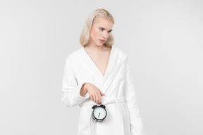 Young blond-haired man in a white bathrobe going about his morning routine