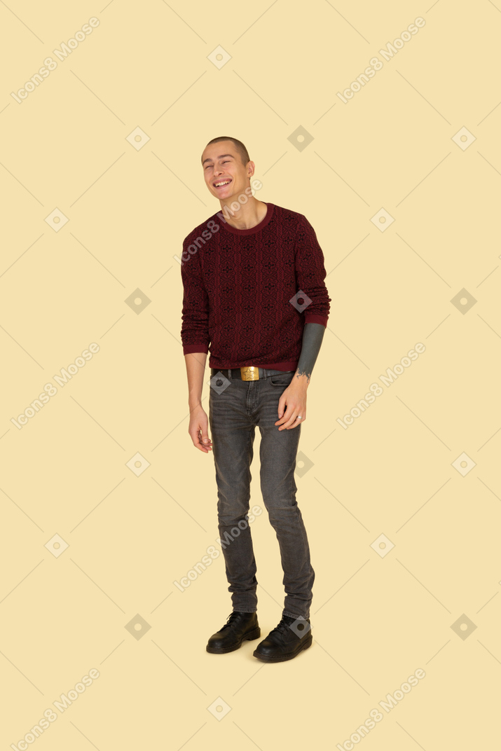 Vista de tres cuartos de un joven riendo en ropa casual