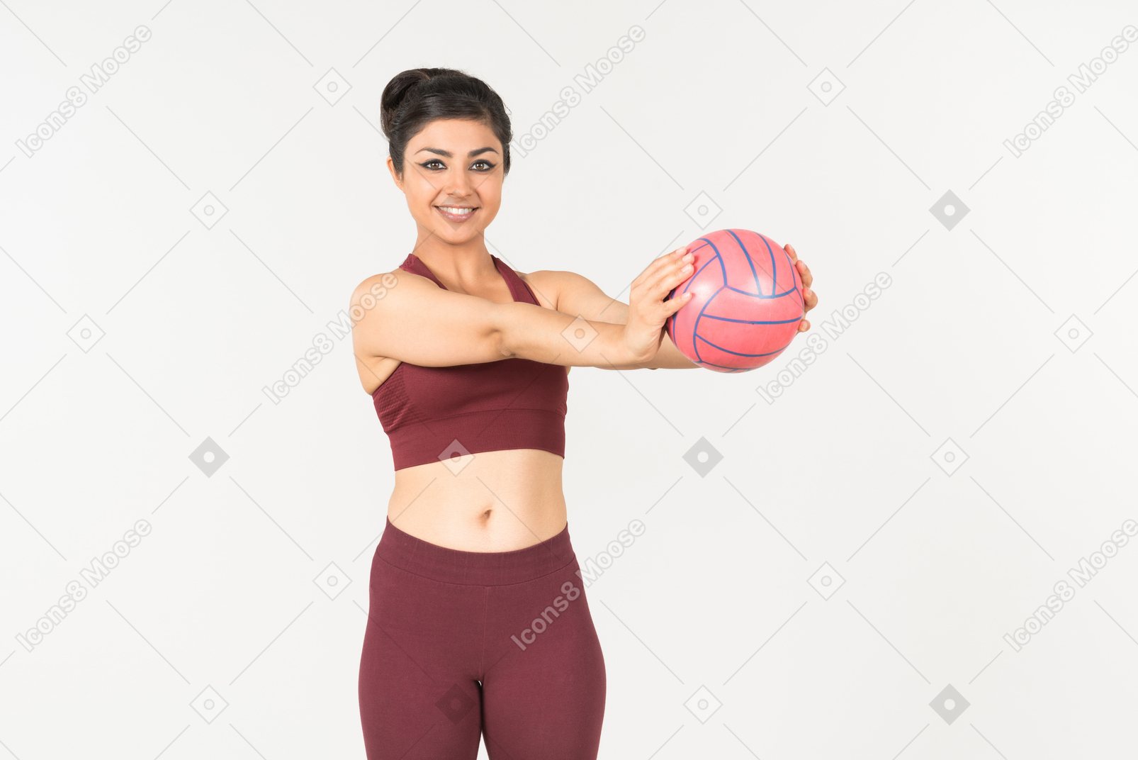 Молодая индийская женщина в спортивном костюме, держа мяч