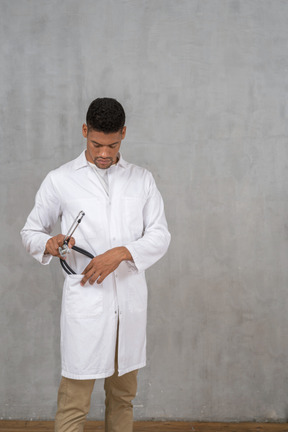 Male doctor putting his stethoscope away