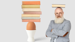 A bald man standing next to an egg and a stack of books