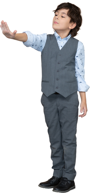 Front view of a boy in grey suit showing stop gesture