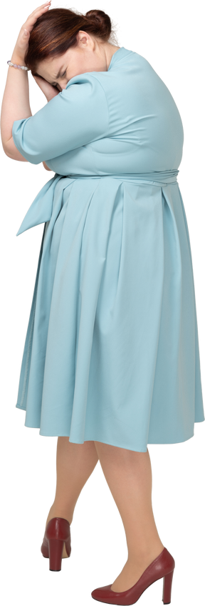 頭に触れる青いドレスの女性の側面図