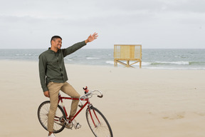 A man riding a bicycle on the beach