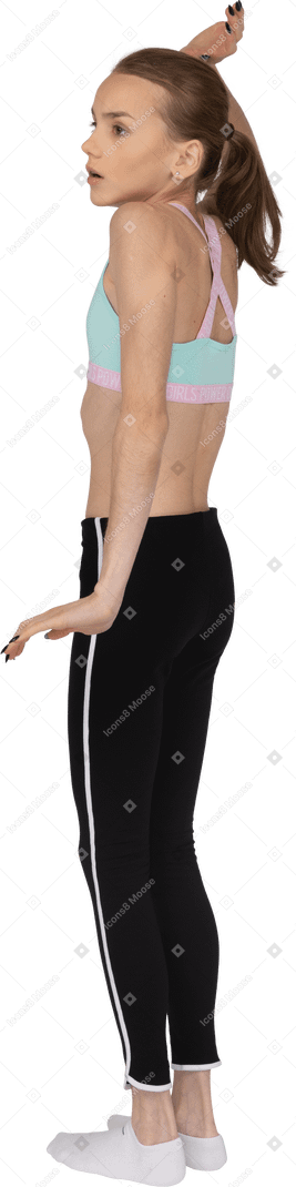 Vista lateral de uma adolescente assustada em roupas esportivas, levantando a mão e abrindo a boca