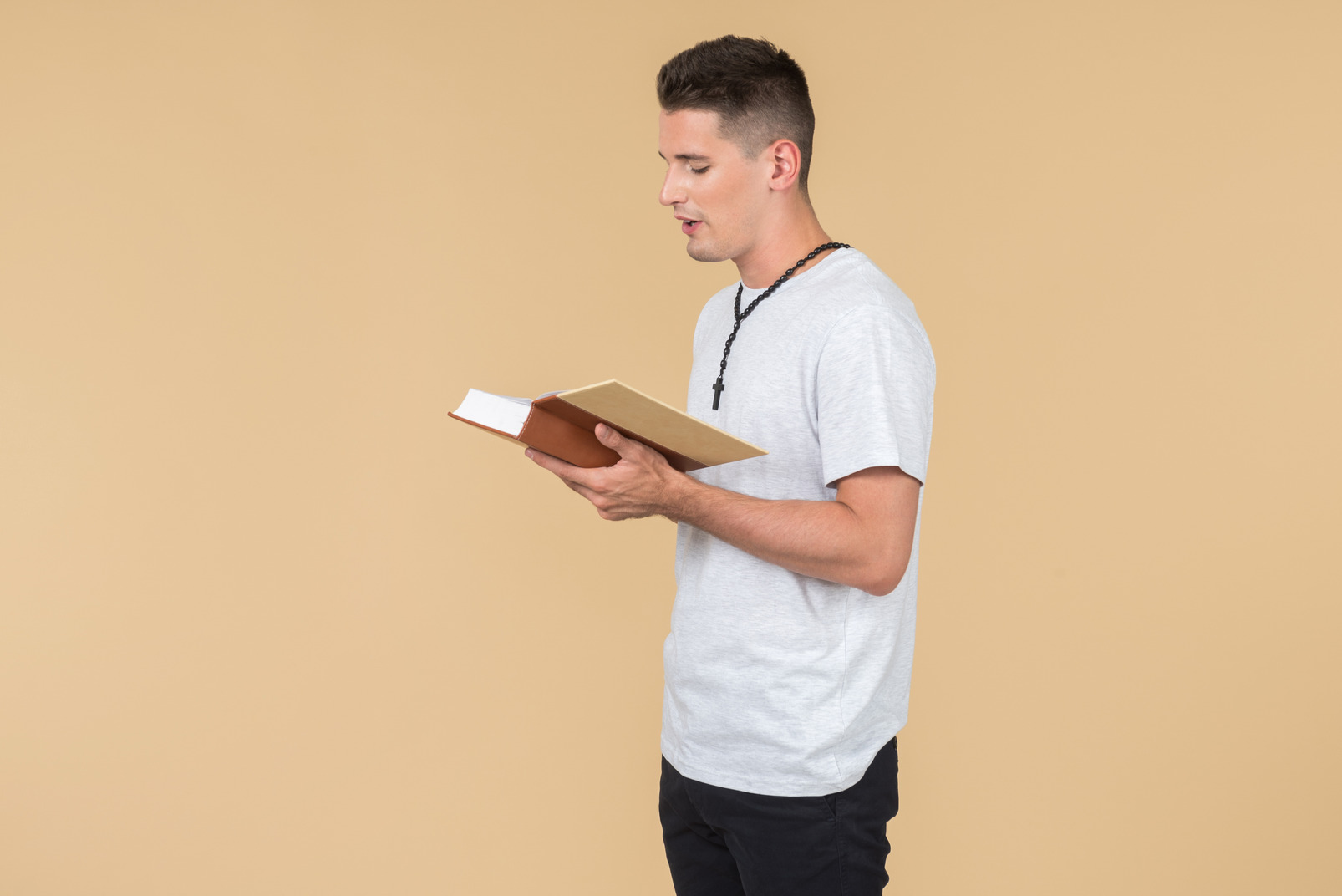 Young guy with prayer beads reading bible and like proclaiming something