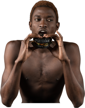 Front view of a young afro man biting a burger