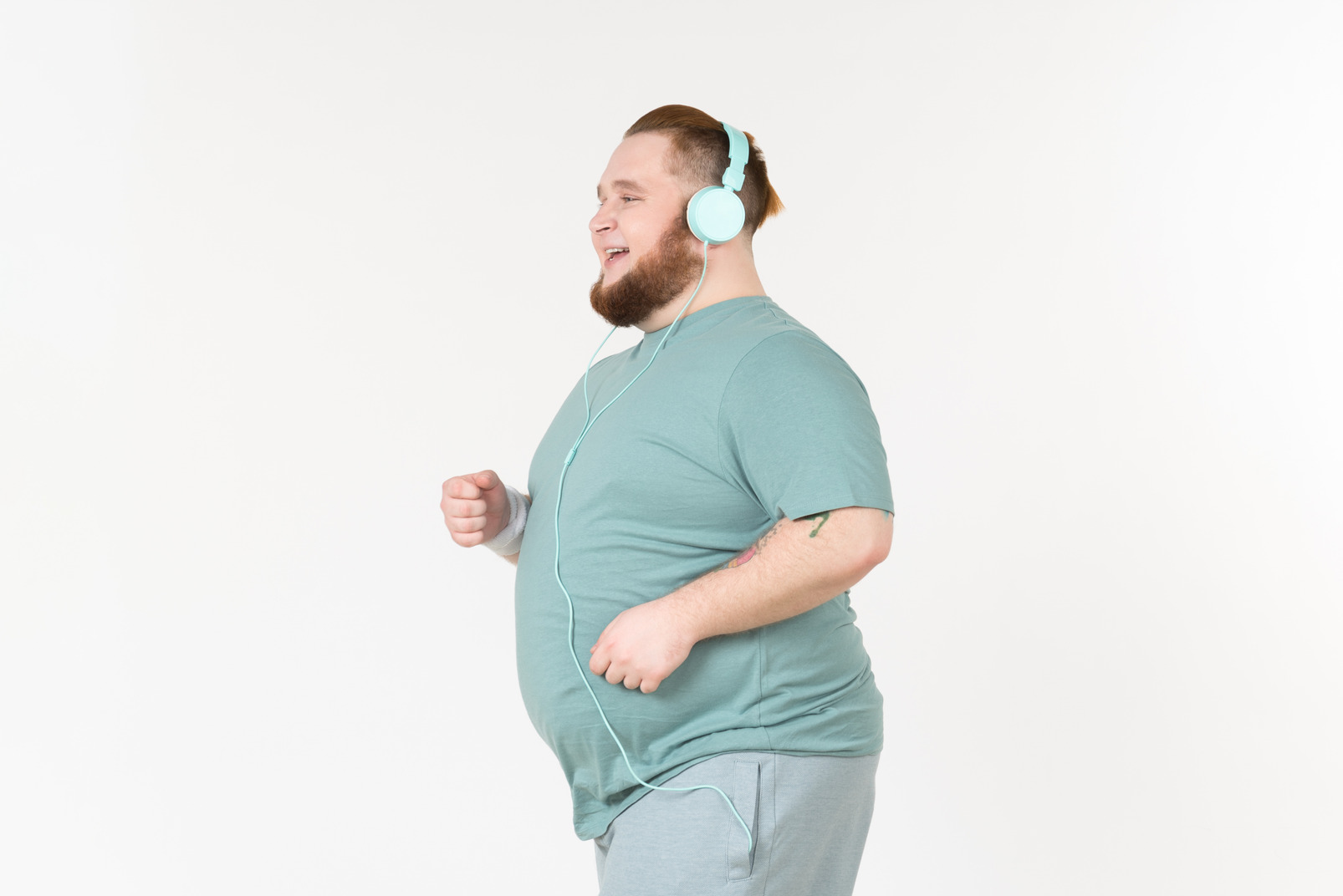 Young overweight man jogging and wearing headphones