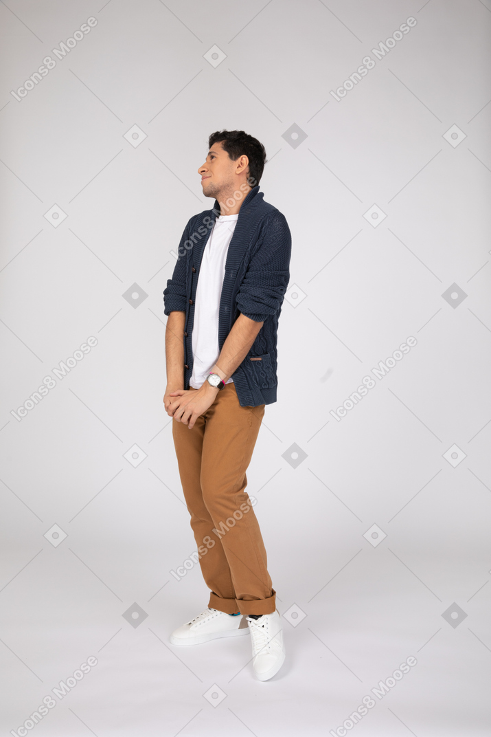 Shy young man standing with his hands together