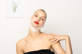 Femme avec la tête bandée posant la main sur l'épaule