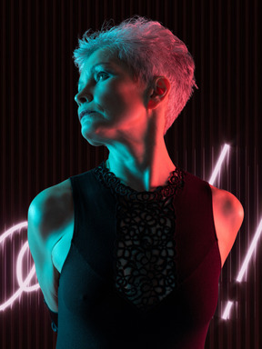 Woman with short hair standing in neon lighting