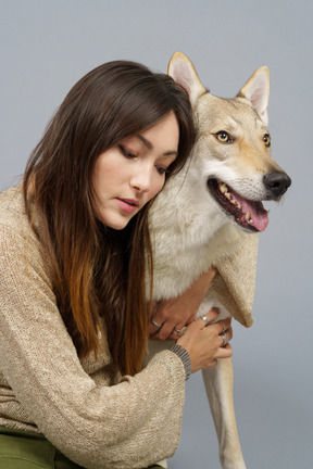 彼女の犬を抱き締める若い女性マスターのクローズアップ