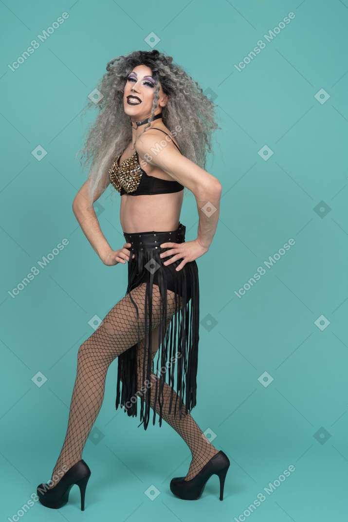 Drag queen in all black outfit walking with hands on hips