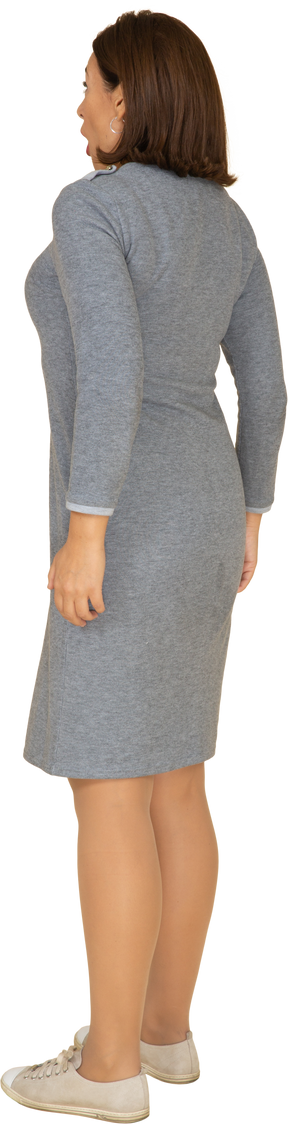 Vista lateral de uma mulher impressionada em um vestido cinza