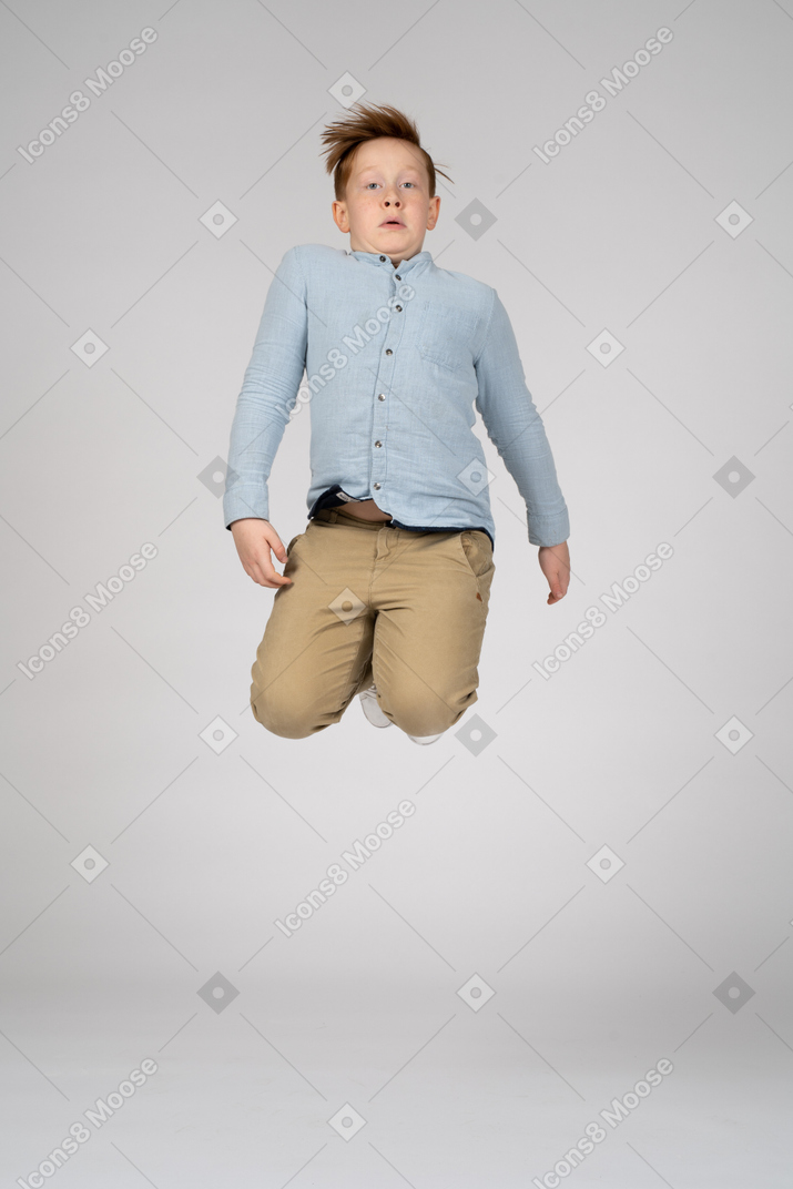 Front view a boy jumping with bent knees