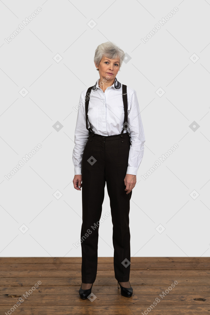 部屋にじっと立っている事務服を着た老婆の正面図