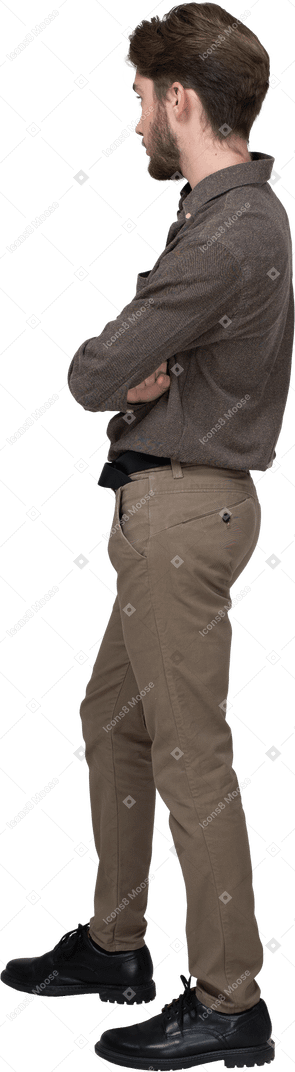 Vista posteriore di tre quarti di un giovane in abiti da ufficio che incrociano le braccia
