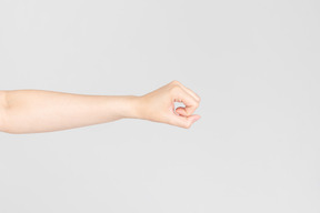 Side look of female hand almost clenched in a fist