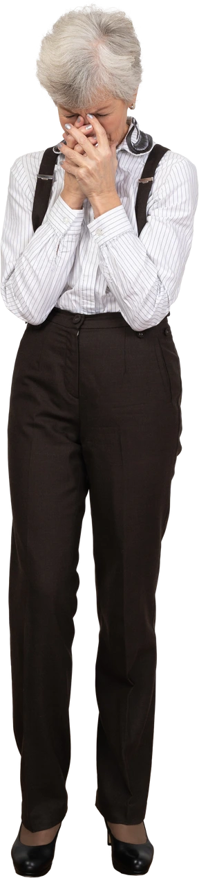 Front view of a worried old lady in office clothing holding hands together