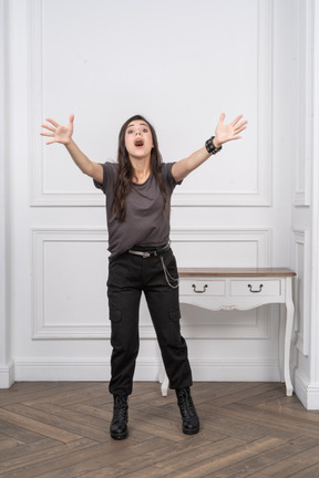 Vue de face d'une femme à bascule surprise étendant ses mains