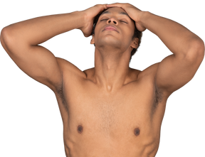 Vista frontal de un hombre afro sin camisa tocando su cabeza