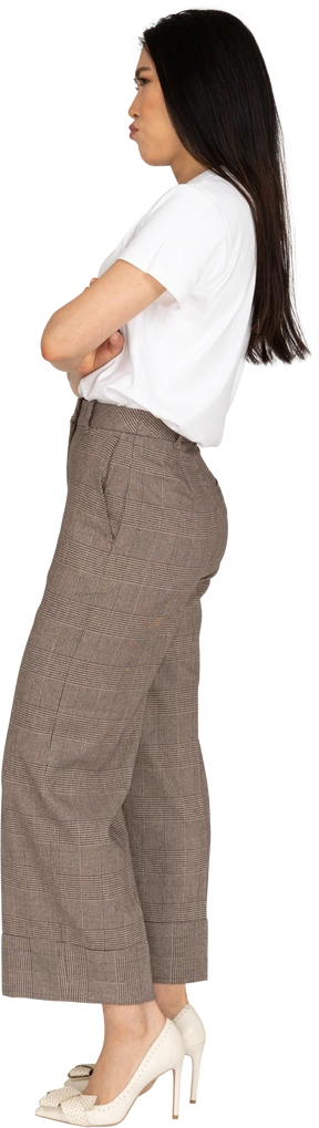 Side view of a pouting young lady in breeches and t-shirt crossing hands