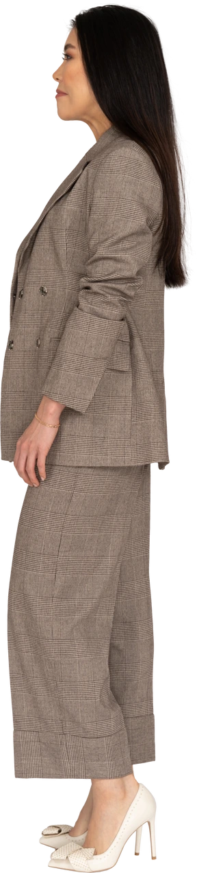 Side view of a young lady in brown business suit looking aside